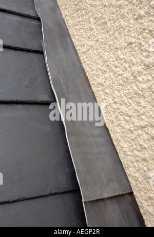 Un toit en ardoise SE JOINDRE À UN MUR AVEC CLIGNOTANT PLOMB RENDU Banque D'Images