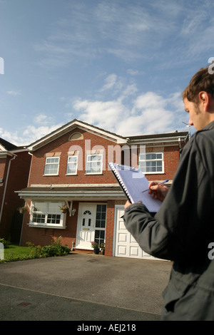 Un jeune homme qui travaille comme arpenteur effectue un sondage auprès d'un logement neuf en amont d'une vente immobilière. Banque D'Images