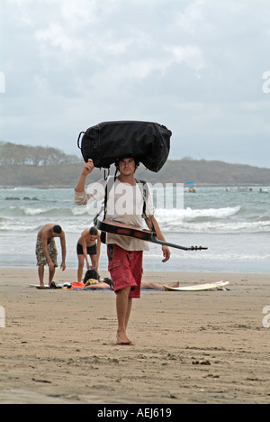 Un musicien marche sur plage de Tamarindo, Costa Rica Banque D'Images