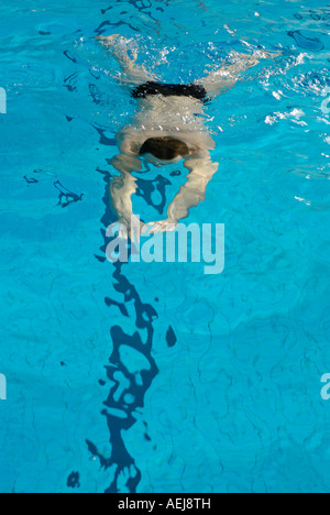 L'homme nage dans une piscine d'hall Banque D'Images