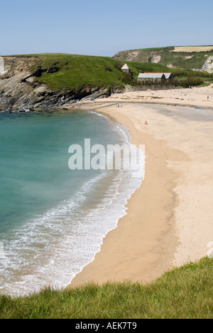 Jour d'été paysage calme mer turquoise se traînant sur la plage de sable de Cornwall à Church Cove Gunwalloe avec l'église de Saint Winwaloe au-delà de l'Angleterre Royaume-Uni Banque D'Images