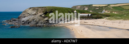 Vue panoramique mer & plage de Cornouailles paysage côtier à l'Église Cove Gunwalloe Cornwall Église de Saint Winwaloe & clocher détaché de personnes sur la plage Banque D'Images