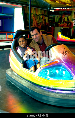 Père et fille jouer dodgems lors d'une foire dans 'Milly la Foret', France Banque D'Images