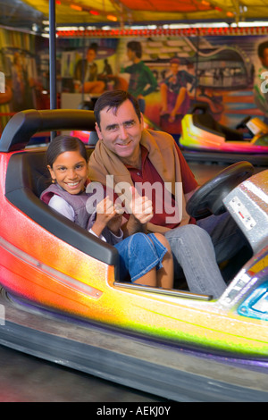 Père et fille jouer dodgems lors d'une foire dans 'Milly la Foret', France Banque D'Images