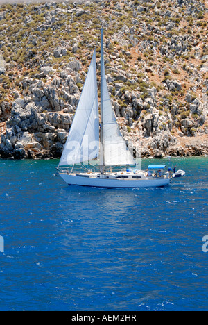 Un voilier naviguant dans la mer au large de l'île de Symi, Grèce Banque D'Images