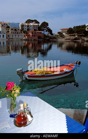 Bateau de pêche amarré au port, table de restaurant en premier plan, Assos, Kefalonia, Grèce Banque D'Images