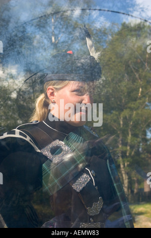 Piper femelle Highland Dress vu à travers la peau transparente de drum Banque D'Images