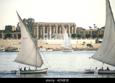 Voile de felouque bateaux transportant des touristes et à cargoe en face du temple de Louxor en Haute Egypte Banque D'Images