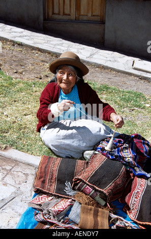 Vieille dame filage de la laine, du marché de Pisac, Pisac, près de Cusco, Pérou Banque D'Images