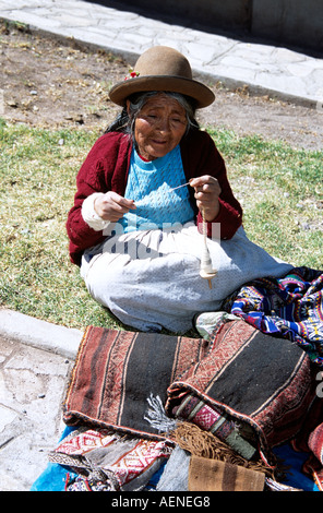 Vieille dame filage de la laine, du marché de Pisac, Pisac, près de Cusco, Pérou Banque D'Images