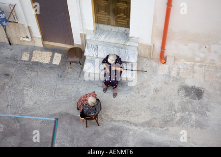 Vue de dessus de deux vieilles dames assis à l'ombre dans la ville antique de Ceglie Messapica, Pouilles, Italie Banque D'Images