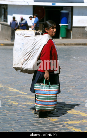 Sac de dame péruvienne par-dessus son épaule, traversant une route, Cusco, Pérou Banque D'Images