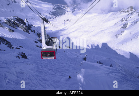 Un câble voiture pleine de skieurs arrive au sommet de la Saulire à Courchevel 1850, dans les alpes françaises Banque D'Images