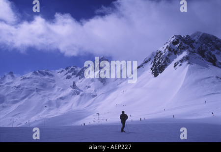 Un skieur solitaire en haut de la Loze dans la station de ski française de Courchevel 1850 regarde vers le sommet de la Saulire Banque D'Images