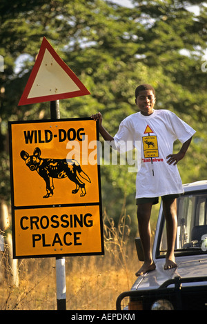 Zimbabwe Bulawayo, signe de route traversant la place de chien de chasse peint. Campagne pour la protection de l'enfant Banque D'Images