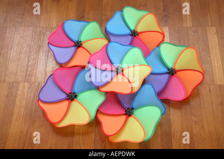 Six moulins à vent multicolores avec chevauchement des lames en forme de coeur en forme de pentagramme sur le plancher en bois de teck. Banque D'Images