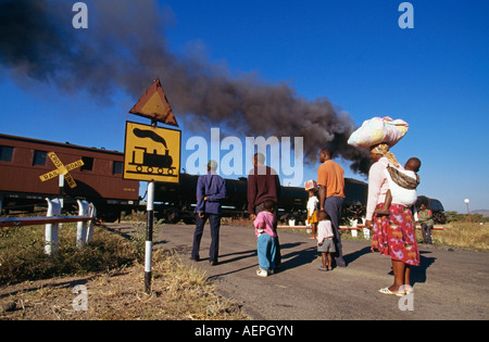 Bulawayo au Zimbabwe, les gens qui se trouvent en passage à niveau, train à vapeur avec Banque D'Images