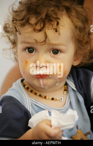 Kleinkind 18 Monate alt JONI mit Bernsteinkette um den Hals beim Essen mit Gesicht verschmiertem Parution Modèle Banque D'Images