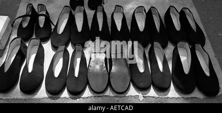 Rangées de chaussures à semelles de cuir traditionnel chinois mis à la vente à un marché dans un hutong de Beijing 2003 La Chine Banque D'Images