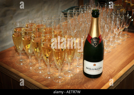 Bouteille de champagne à côté de flûtes verres rempli prêt pour un cocktail de célébration de mariage à un petit-déjeuner Banque D'Images