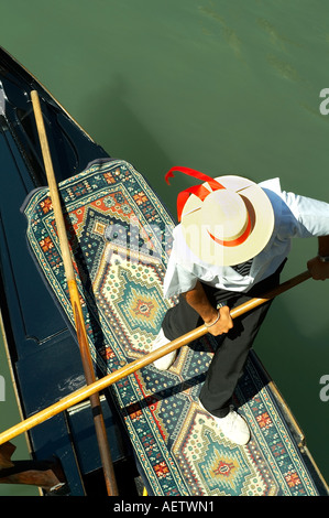 Gondolier dans une gondole portant un chapeau de paille avec ruban rouge Banque D'Images