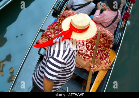 Gondolier dans une gondole portant un chapeau de paille avec ruban rouge Banque D'Images