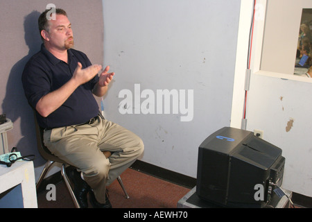 Miami Florida,Board of Education,White man,male utilisant la langue des signes,bilingue pour les sourds regardant la réunion télévisée, les visiteurs voyagent tour touri Banque D'Images