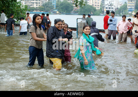 Les femmes en marche genou profondément l'eau de la mousson à Bombay pluie record du monde maintenant Mumbai Inde Banque D'Images