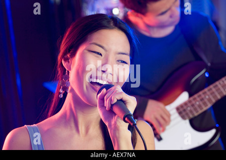 Woman singing into microphone avec le guitariste Banque D'Images