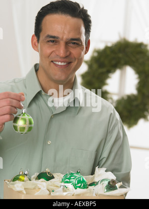 Portrait of man holding Christmas ornament Banque D'Images