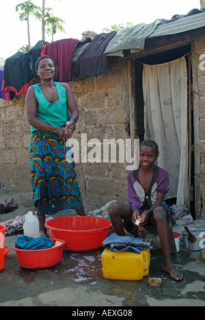 Mère et fille faire la lessive à l'extérieur de leur maison à Lusaka. La Zambie, l'Afrique Banque D'Images
