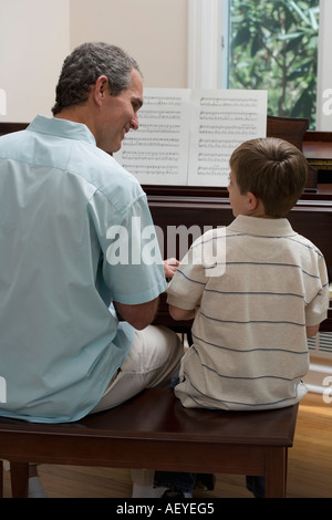 Le père et le jeune fils à jouer du piano Banque D'Images