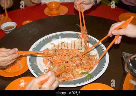 Manger Yee Sang pendant le Nouvel An chinois Banque D'Images