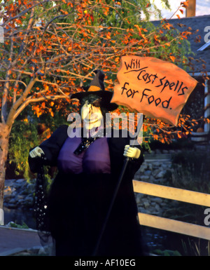 Une grande sorcière se tient une pancarte avec bâti de charme en échange de nourriture. Banque D'Images