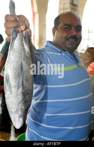 Un poissonnier Goan montrant un poisson frais sur le marché aux poissons à Margao Salcete Goa Inde Banque D'Images