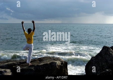 Faire du yoga dans PULINGUDI BEACH À KOVALAM TRIVANDRUM Banque D'Images