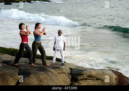 Faire du yoga dans PULINGUDI BEACH À KOVALAM TRIVANDRUM Banque D'Images