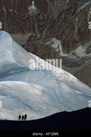Une partie des trois alpinistes en ordre décroissant une crête élevée dans les Alpes françaises avec la Vallée Blanche derrière Banque D'Images