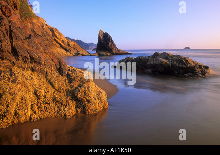 Le coucher du soleil colore les bluffs à l'aire de loisirs d'état de Hug Point sur la côte de l'Oregon, USA Banque D'Images