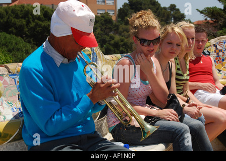 Les adolescentes en interaction avec busker assis sur banc de parc en Parc Guell Barcelone Banque D'Images