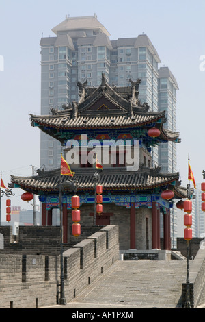 La pagode chinoise traditionnelle des capacités en contraste avec une tour moderne en forme de tour en arrière-plan, les murs de la ville de Xian, Chine Banque D'Images