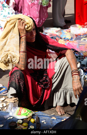 Femme indienne de la tribu rabari avec bras et pieds tatouages qui la met à l'abri du soleil, Vanakbara Fishing Village, DIU Island, Gujarat, Inde Banque D'Images