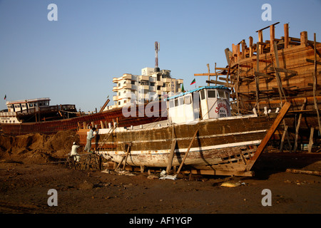 Petit bateau en cours de rénovation dans un chantier naval en bois, Mandvi, Kutch, Gujarat, Inde Banque D'Images