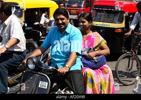 Couple indien sur scooter sans casque dans la circulation, Nasik, Inde Banque D'Images