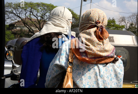 Vue arrière des femmes indiennes portant des foulards de tête en scooter dans la circulation, Pune, Inde Banque D'Images