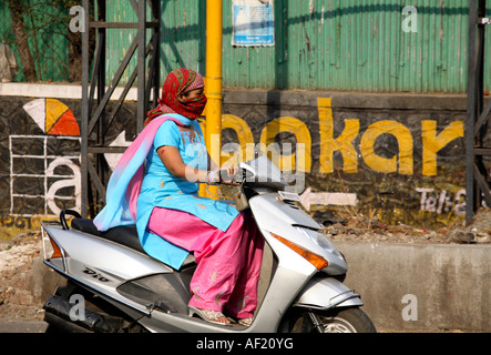 Femme indienne à cheval dans la circulation occupée sans casque d'accident, Pune, Inde Banque D'Images