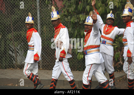 Musiciens indiens vêtus de leur uniforme de groupe garish marchant dans les rues de Pune, Inde Banque D'Images