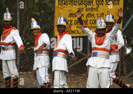 Musiciens indiens dans leur uniforme de groupe flamboyant coloré marchant dans les rues de Pune, Inde Banque D'Images