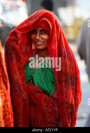 Rabari Tribal Woman avec des tatouages de cou protégeant le visage de la lumière du soleil, una, Gujarat, Inde Banque D'Images