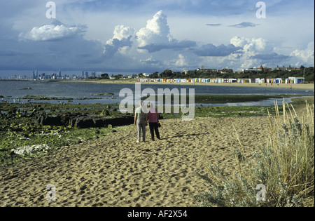 Couple à la plage de Brighton en regardant vers le centre-ville de Melbourne, Victoria, Australie Banque D'Images
